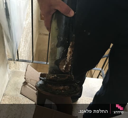 אדם מחזיק דוד שמש ישן עם חלודה